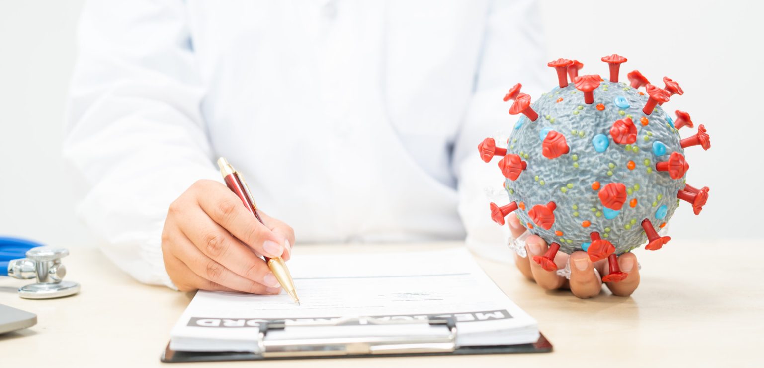 A female doctor sits at a table in a hospital, discussing the COVID-19 virus.She explains origins